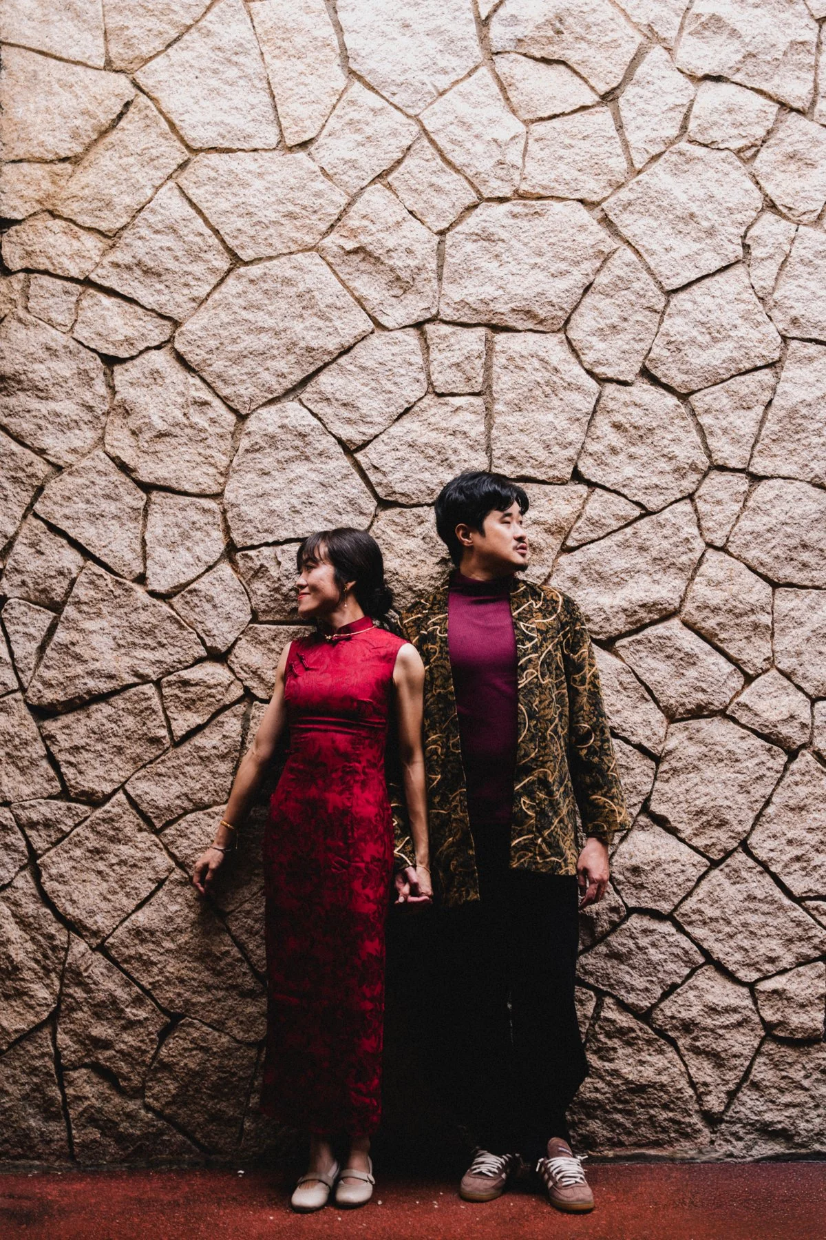 Andrew and Pheobe together beside a textured stone wall