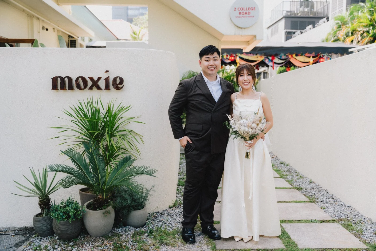 Jason and Belle standing outside the venue marked Moxie