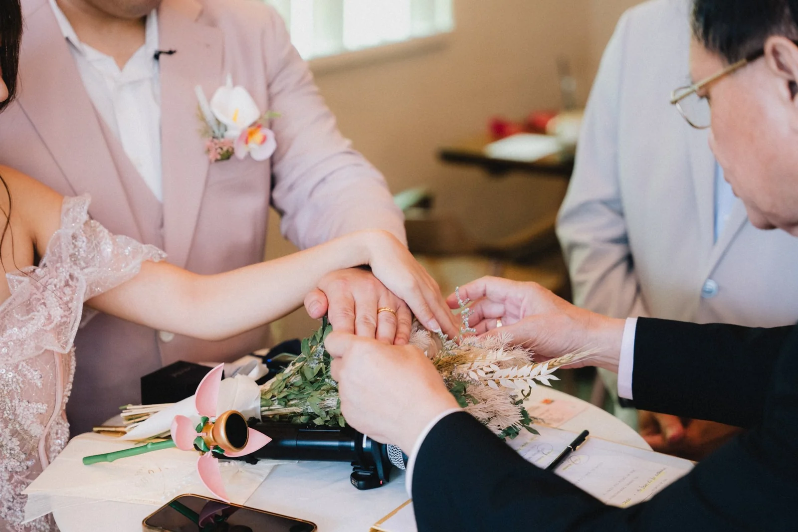 A close photograph of Jason and Belle exchanging rings