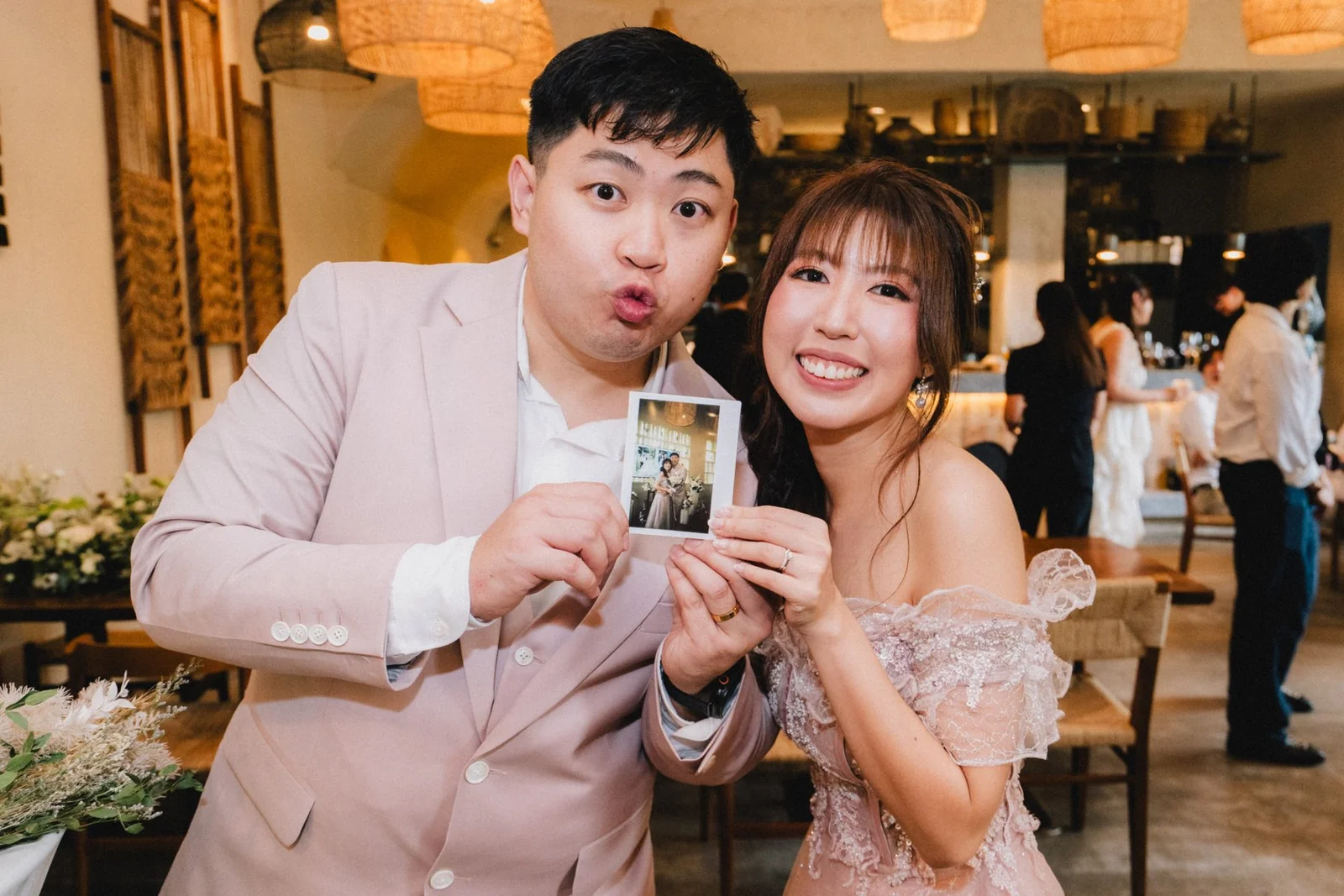 Jason and Belle holding up a small printed photograph together